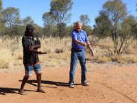 Aborigines teaching the art of throwing a boomarang